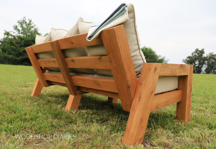 Back and side view of finished DIY outdoor sofa showing cedar slat construction and frame joinery
