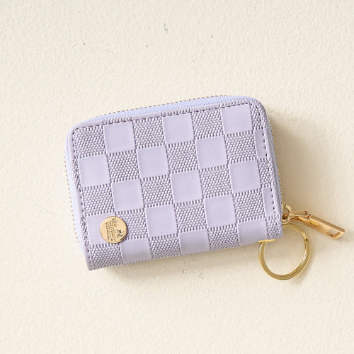 The Darling Effect Periwinkle Check Zip Around Wallet, featuring a gold zipper, convenient card slots, and a handy keyring, is shown on a light beige surface.