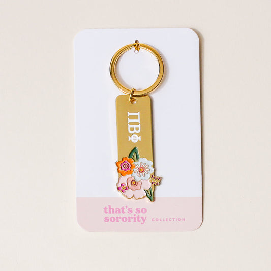 The Darling Effect's Pi Beta Phi Enamel Keychain features Greek letters and a floral design, attached to a white and pink card labeled "That's So Sorority Collection.
