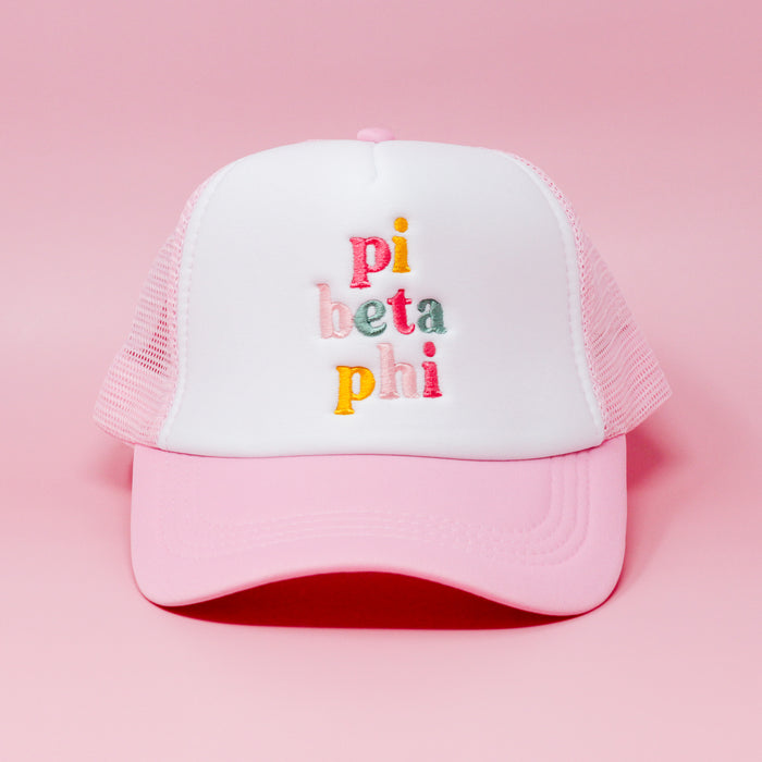 The Darling Effect’s Pi Beta Phi Pink Trucker Hat features pink and white embroidery with colorful stacked text, shown on a solid pink background—ideal as a stylish sorority hat or thoughtful chapter gift.