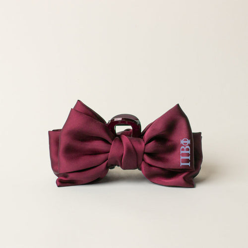 A burgundy satin bow tie with silver Greek letters embroidered on the right, perfect for pairing with The Darling Effect’s Pi Beta Phi Satin Bow Claw Clip, is shown against a plain light background.