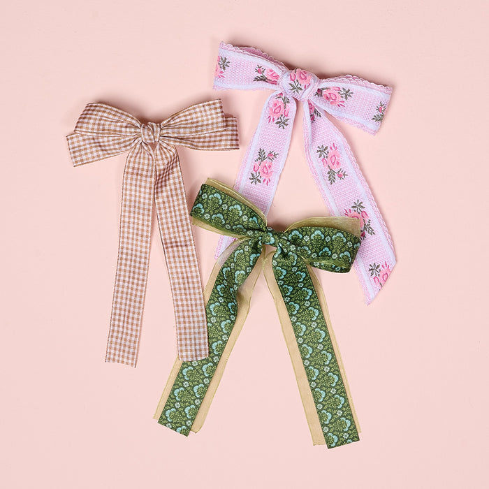 The Darling Effect’s Pink Heirloom Rosette Hair Bow is a charming hair accessory, featuring a pink floral design—perfect for adding a stylish touch to any look.