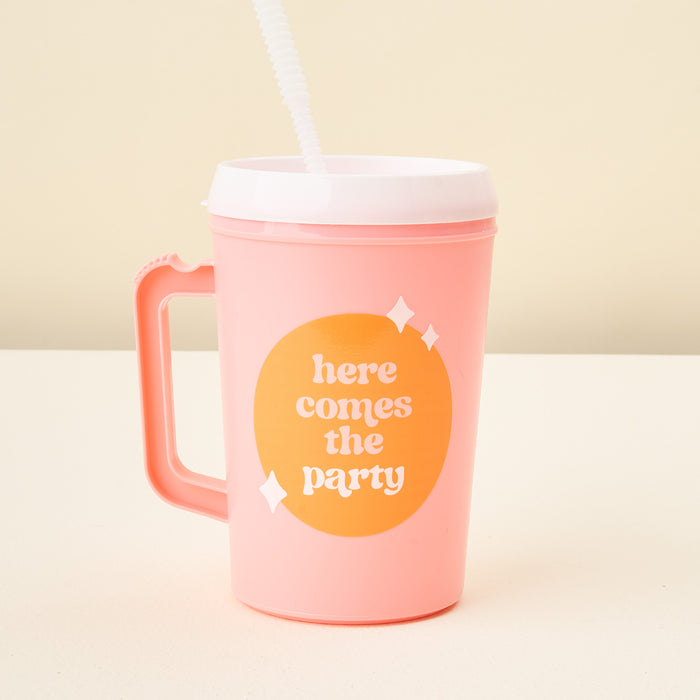 The Darling Effect Pink Here Comes the Party 34 oz Mega Mug features a handle, white lid, straw, and an orange circle with playful white lettering and sparkles.