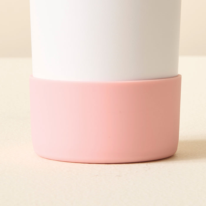 A close-up of The Darling Effect's Pink Tumbler Silicone Boot, featuring a matte white top and a smooth light pink base, displayed on a pale textured surface.