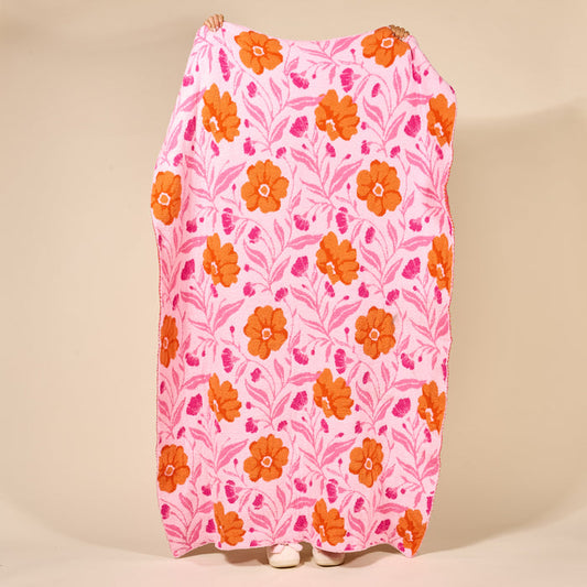 A person holds up The Darling Effect's Poppin' Petals Hot Pink Cozy Dreams Luxe Blanket, featuring an orange and red floral pattern; only their hands and feet peek out from behind the ultra-soft blanket.
