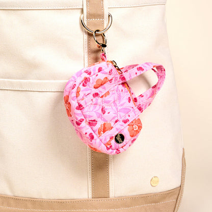 The Darling Effect's Poppin' Petals Hot Pink Itty Bitty Duffle Bag Charm is clipped to a beige and tan canvas bag with a silver keyring, making it the perfect floral quilted accessory or bag charm.