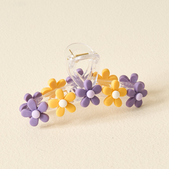Show off your school spirit with The Darling Effect’s Purple Yellow Game Day Daisy Claw Clip, featuring purple and yellow daisies on a cream background—perfect for adding playful style to your game day look.