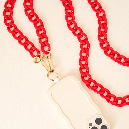The Darling Effect’s Red Game Day Phone Chain features a wavy-edged white case with a gold clasp and bold red chain strap—an eye-catching accessory for game day, shown on a light surface.