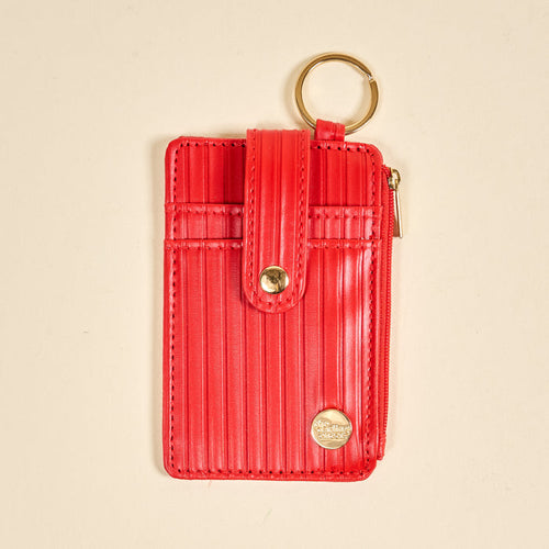 The Darling Effect Red Ripple Ridge Keychain Wallet features card slots, a gold keyring, snap button closure, side zippered coin holder, and a gold emblem at the bottom right corner, shown on a beige background.