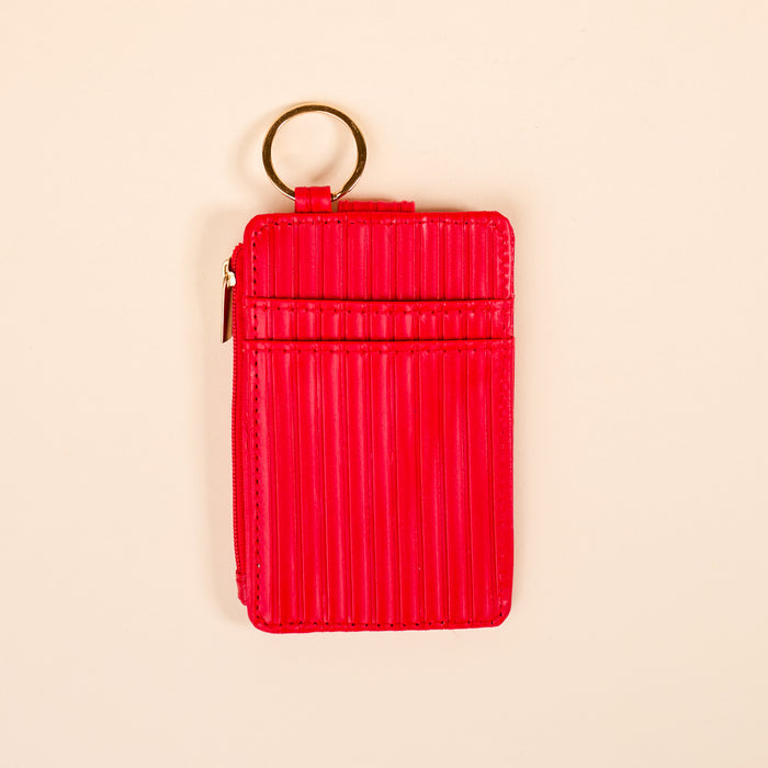 The Darling Effect’s Red Ripple Ridge Keychain Wallet features a textured bright red finish, card slots, zippered coin pocket, and metal keyring—shown on a light beige background.