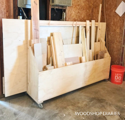 DIY mobile scrap and plywood storage cart on caster wheels, loaded with plywood sheets and lumber scraps in a garage workshop