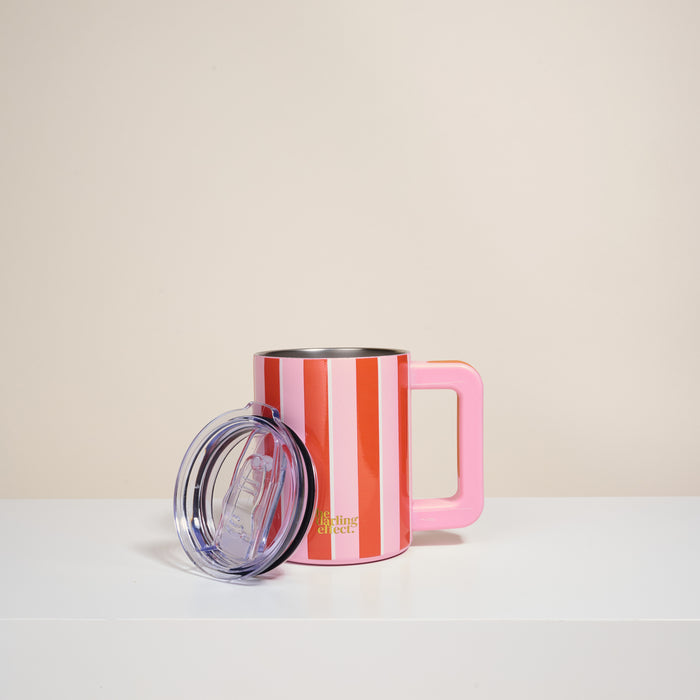 The Sicily Stripes Pink 14 oz Insulated Mug by The Darling Effect features red and white stripes, a large pink handle, and double-wall insulation. A clear plastic lid sits in front, with "Darling Street" in gold near the bottom on a white surface.