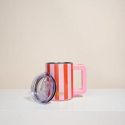 The Sicily Stripes Pink 14 oz Insulated Mug by The Darling Effect features red and white stripes, a large pink handle, and double-wall insulation. A clear plastic lid sits in front, with "Darling Street" in gold near the bottom on a white surface.