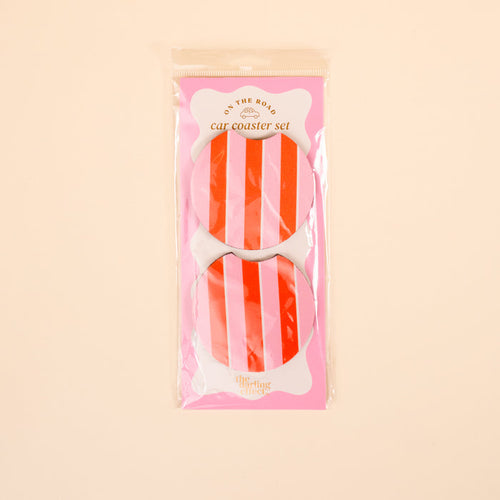 The Darling Effect’s Sicily Stripes Pink On the Road Car Coaster Set includes two round absorbent coasters with red and white stripes, displayed on a pink card against a light beige background.