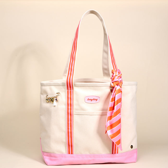 The Darling Effect's Sicily Stripes Pink The Darling Canvas Tote Bag features a white canvas body, bright pink base, pink accents, striped handles, a stylish scarf on one handle, gold charm on the pocket, and a spacious interior.