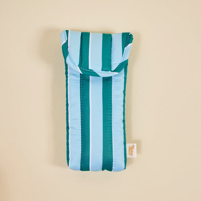 The Darling Effect's Sicily Stripes Teal Puffy Sunglasses Case features teal, light blue, and white stripes, a small bottom tag, quilted protection for eyeglasses, and a secure magnetic flap closure.