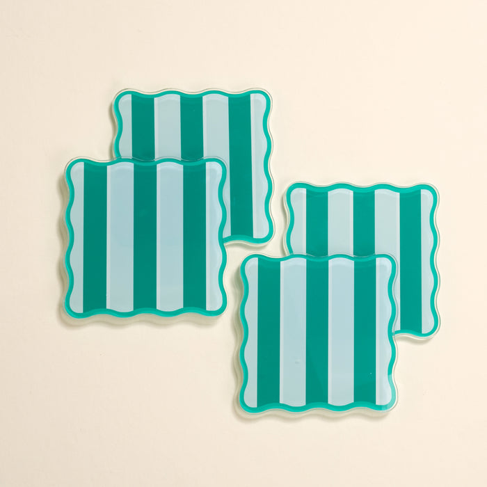 The Darling Effect’s Sicily Stripes Teal Table Talk Acrylic Coaster Set includes four wavy-edged coasters with bold teal and light blue stripes—stylish, heat-resistant décor for any table setting.