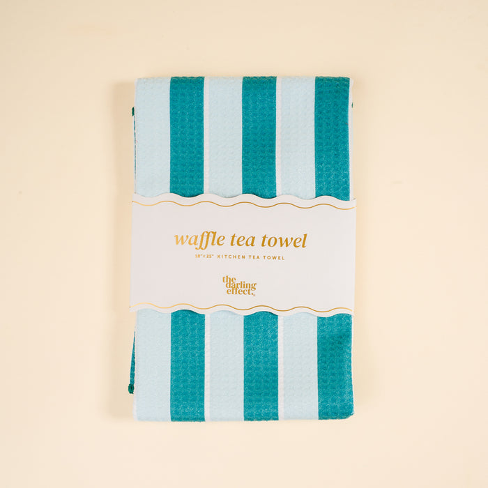 The Sicily Stripes Teal Waffle Tea Towel by The Darling Effect measures 18x25" and features teal and light blue stripes—an absorbent, stylish addition to any kitchen.