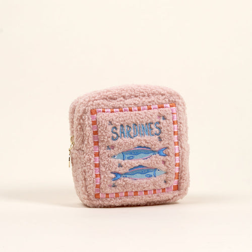 The Darling Effect Square Sardines Teddy Pouch is a small, pink, sherpa pouch with a fuzzy texture, side zipper, and embroidered patch featuring two blue sardines and the word "SARDINES.