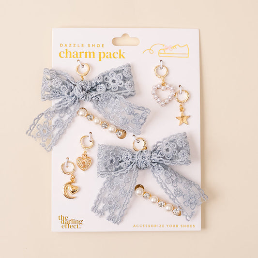 The Stardust Dazzle Shoe Charm Pack from the-darling-effect features light blue lace bows and gold heart, star, and pearl charms—stylish shoe accessories to elevate your look.