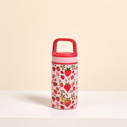 The Darling Effect’s Strawberry Fields 6 oz Lil' Bitty Bottle features a pink petite design with a red handle, strawberry and green leaf accents—an adorable hydration companion for travel, shown on a white surface against a light beige background.