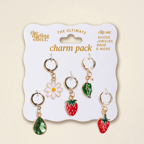 A pack of five gold charm clips—green teardrop, white daisy, green leaf, and two red strawberries—displayed on a Strawberry Meadow The Ultimate Charm Pack card by The Darling Effect. Perfect to pair with Scrunchie Charm Sets for extra flair!.