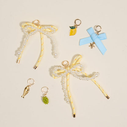 Add a splash of summer to your sneakers with The Darling Effect’s Summer Soirée Dazzle Shoe Charm Pack—featuring pearl-beaded yellow bows, a lemon, blue starfish bow, golden fish, and green grapes for irresistible charm.