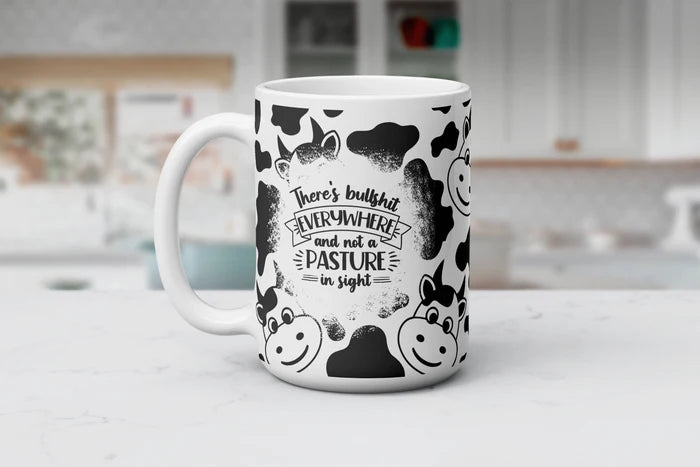 Funny cow print coffee mug featuring cartoon cows and the phrase there's bullshit everywhere and not a pasture in sight.