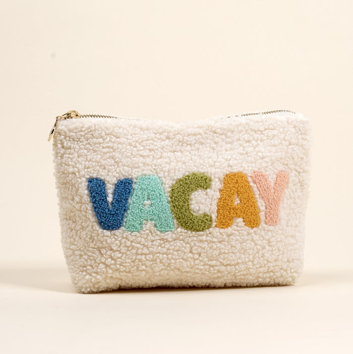 The Darling Effect's Vacay Teddy Pouch features white sherpa fabric and multicolored "VACAY" embroidery on a cream background—a cozy, stylish accessory for your collection.