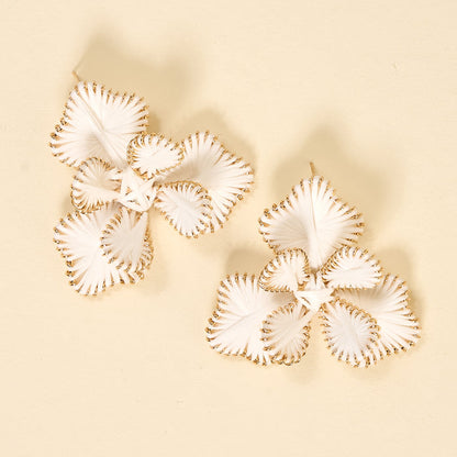 The Darling Effect’s White Main Character Earrings are statement boho florals with white petals and gold edges, displayed on a beige background—lightweight and perfect for everyday wear.