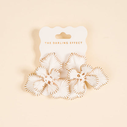 White Main Character Earrings by The Darling Effect: petal-shaped white earrings with gold trim on a light peach background, lightweight for everyday wear, displayed on a card reading THE DARLING EFFECT.