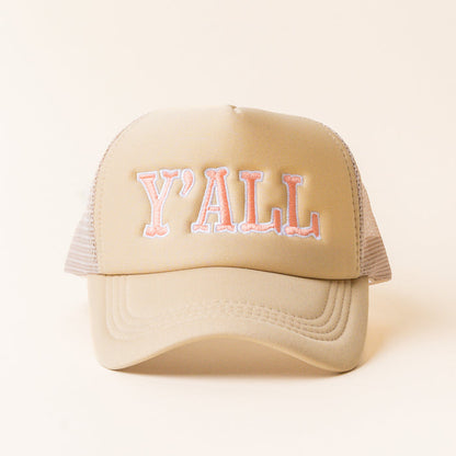The Y'all Trucker Hat by the-darling-effect is a trendy beige hat with peach-colored "YALL" embroidered text.